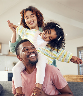 pai de familia negra e filha brincando com mae no sofa da sala juntos para se divertir em casa pai feliz carregando crianca para passeio nas costas com mae no sofa da sala aproveitando as ferias